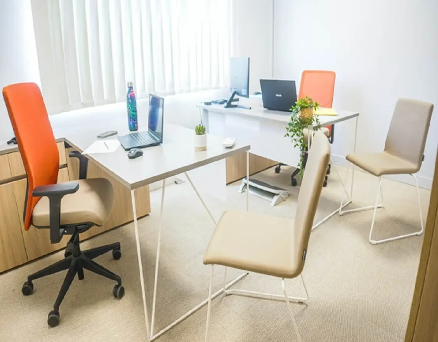 Bureau clair de deux places avec fauteuils et postes informatiques